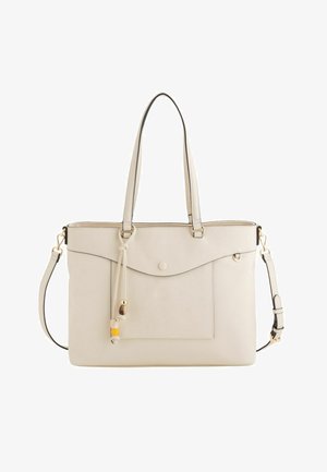 Cremefarbene Tragetasche mit zwei Griffen, abnehmbarem Schultergurt, vorderer Klappentasche und dekorativen Perlen an einem Lederquast.