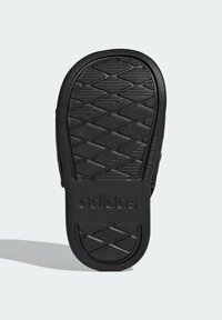 Musta kumisaapas pohja, jossa on teksturoitu timanttikuvio ja kohokuvioitu logo. Ominaisuuksiin kuuluu sileä pinta, kaartuvat reunat ja tasainen kanta.