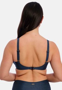 Tmavě modrý bikiny vršek s nastavitelnými šňůrkami a háčkovým zapínáním na zadní straně; hladká textura a minimální branding na pásku.