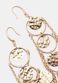 Náušnice v zlatej farbe s vy hammered guľatými pendanta, prepojené reťazami. Obsahuje dizajn s rybárskym háčikom pre jednoduché nosenie.