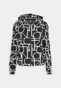 Kapuzensweatjacke aus schwarzem Stoff mit einem weißen geometrischen Muster und fettem Schriftzug. Enthält elastische Bündchen und einen taillierten Saum.