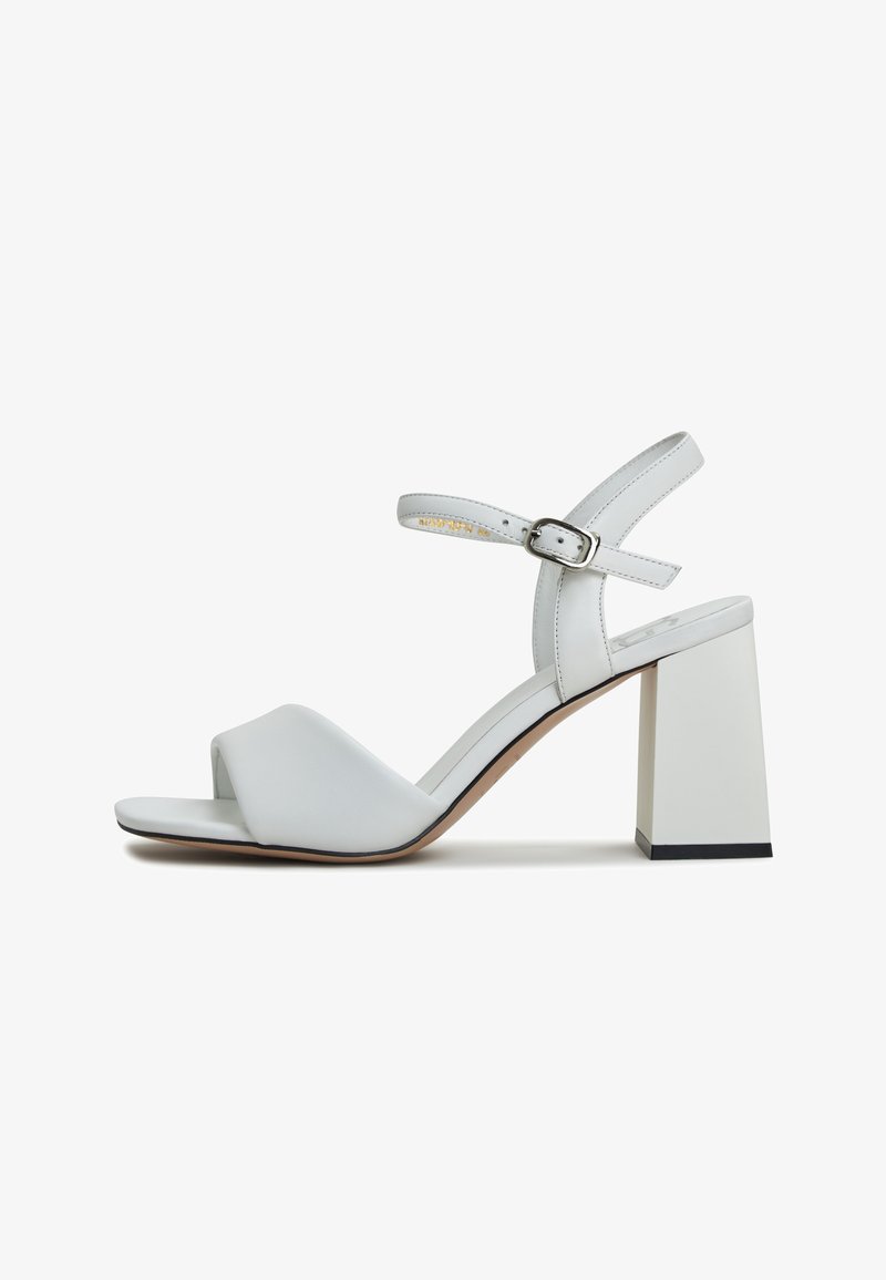 Bílé sandály na podpatku se hladkým koženým svrškem, otevřenou špičkou, řemínkem kolem kotníku se sponou a čtveratým, robustním podpatkem.