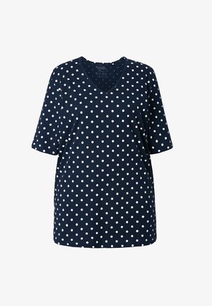 Granatowy top z krótkim rękawem, z dekoltem w serek, wykonany z miękkiego materiału w biały wzór w groszki. Luźny krój z prostym obszyciem.
