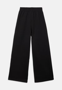 Schwarze weite Hosen mit elastischem Bund, aus weichem Stoff, flach vor einem weißen Hintergrund präsentiert.