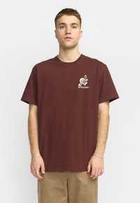 Bordeaux katoenen t-shirt met een klein wit grafisch ontwerp en tekst op de borst, met een ontspannen pasvorm en ronde hals.