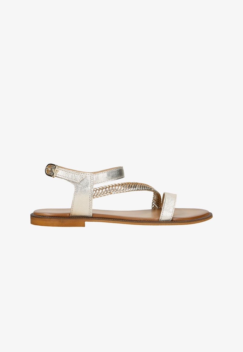 Gouden metalen platte sandalen met geweven bandontwerp, verstelbare enkelgesp en platte bruine zool. Minimalistische constructie.