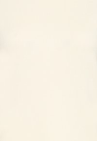 Gros plan sur un tissu tricoté de couleur crème avec une texture côtelée et des détails de motif subtils.