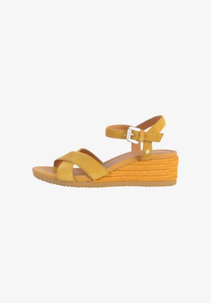 Yellow suede wedge sandals with crossed straps and a buckle ankle strap. Rope texture detail on the wedge heel. Flat sole.
