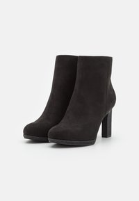 Zwarte suède enkellaarzen met een ronde neus en een textuur blokhak, voorzien van een gladde afwerking en een minimalistisch ontwerp.