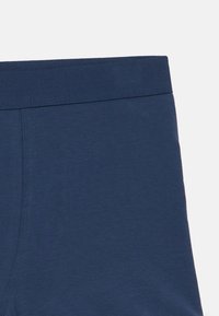 Tmavě modré spodní prádlo s hladkou texturou a elastickým pasem. Vyznačuje se plochými švy pro pohodlí a minimalistickým designem.