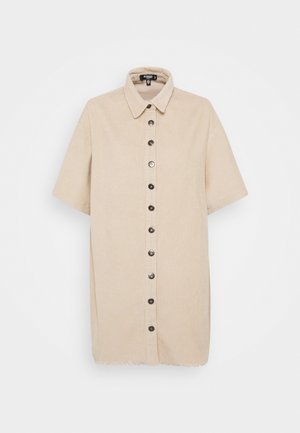 Beżowa sztruksowa sukienka koszulowa z krótkim rękawem, kołnierzykiem i czarnymi guzikami z przodu, z surowym wykończeniem na dole.