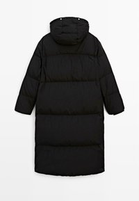 Sort lang dunjakke med hætte, der har et quiltet design og vandrette syninger. Glat tekstur, løs pasform og trykknaplukninger.