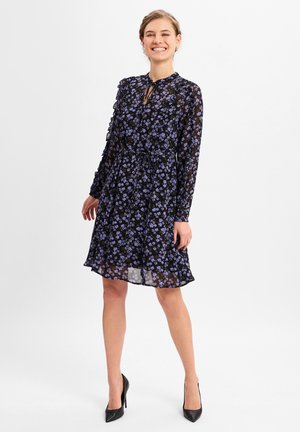 Black sheer dress with purple floral pattern, long sleeves, keyhole neckline, and a cinched waist. Pairing with black high heels.