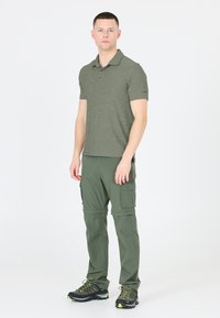 Grønstribet polo shirt med krave, parret med matchende cargo-bukser med lommer, båret med sorte vandrestøvler.
