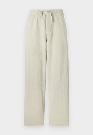 Pantalons larges de couleur gris clair, fabriqués en tissu doux et texturé. Dotés d'une taille élastique avec un cordon de serrage et de poches latérales.