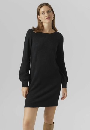 Robe tricotée noire avec une coupe décontractée, de longues manches bouffantes et un col rond. Présente une texture douce et un ourlet légèrement côtelé.