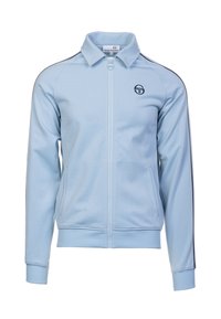 Hellblaues Zip-Jackett aus glattem Material. Merkmale einen Stehkragen, Seitentaschen und marineblaue Akzente entlang der Schulternähte. Logo auf der Brust.