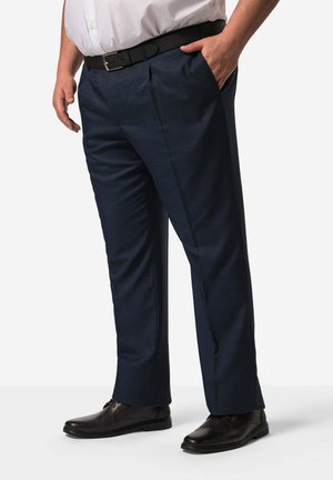 Dunkelblaue Hose aus strukturiertem Stoff, mit zwei vorderen Taschen und einer lockeren Passform, kombiniert mit schwarzen Halbschuhen und einem schwarzen Gürtel.