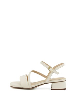 Sandalo beige con punta aperta, tacco basso a blocchetto, cinturino regolabile alla caviglia e sottili cinturini incrociati su sfondo bianco.