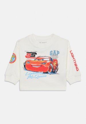 Sweat-shirt blanc GAP à manches longues, orné d’un grand motif rouge de Flash McQueen, du numéro 95 et de textes et écussons sur le thème de la course automobile.