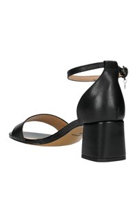 Sandale à talon en cuir noir avec une sangle à la cheville, bout ouvert et talon carré. Texture lisse avec un minimum de détails.