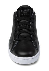 Black leather sneaker with a smooth finish, featuring black laces, perforated detailing, and a white rubber sole. Branding on the tongue.