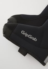 Huse de încălțăminte din neopren negru, cu vârf întărit, țesătură texturată și o curea. Logo-ul "GripGrab" imprimat în argintiu pe lateral.