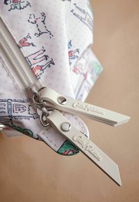 Balta užtrauktuku uždaroma kišenė su žaismingu šunų ir žmonių piešiniu, lengvų rožinių taškelių fone, ir Cath Kidston prekės ženklo užtrauktuko traukliais.