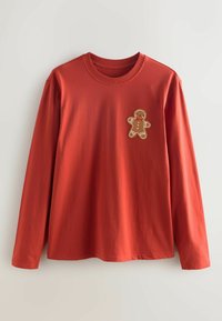 Red long-sleeved shirt in cotton featuring a gingerbread man embroidery on the left chest. Crew neckline and straight hem.