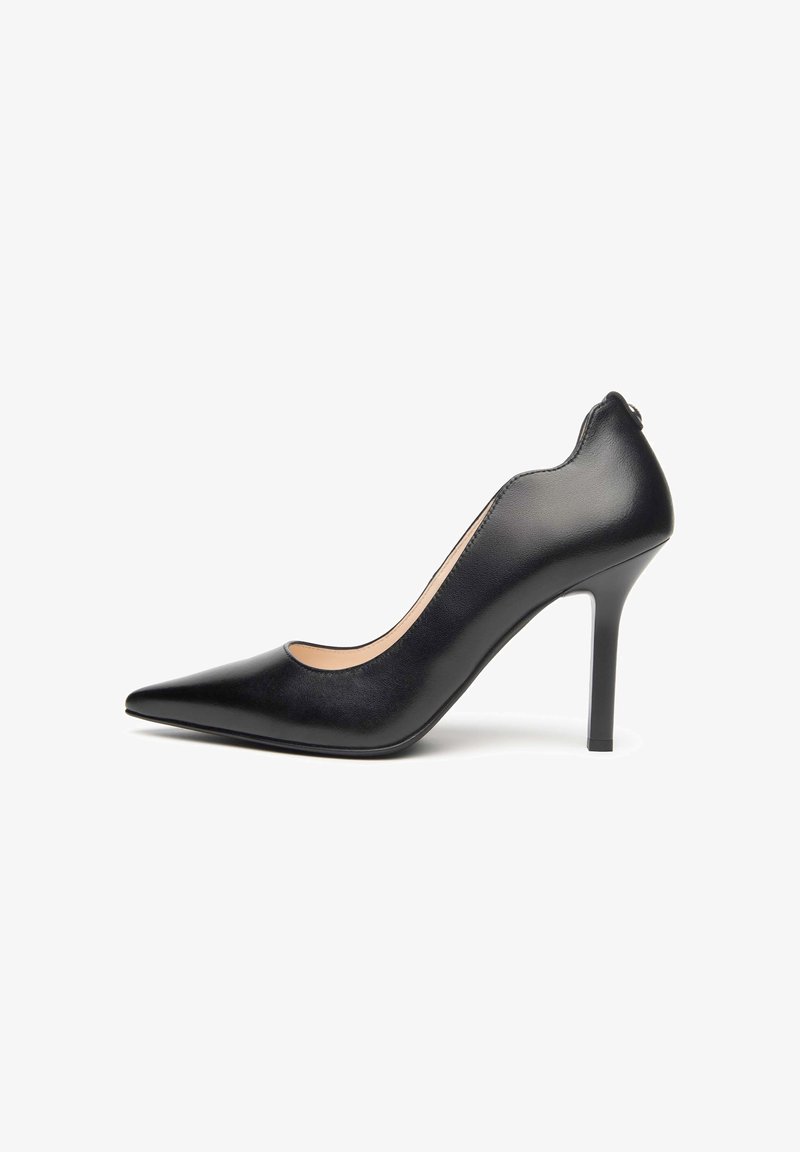 Escarpin à talon haut en cuir noir avec bout pointu, talon aiguille fin et finition lisse, vu de profil sur fond blanc.