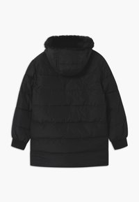 Giacca a vento nera con cappuccio, dotata di una fodera in pelliccia sintetica al colletto, polsini a costine e cuciture orizzontali trapuntate in tutto il capo.