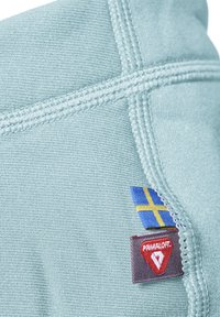 Ljust blått tyg med sömmade kanter har en gul och blå flaggskylt samt en röd Primaloft-logotyp, vilket framhäver materialet och designen.