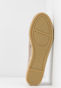 Brązowy zamszowy but o teksturowanej powierzchni, z gumową podeszwą w wzór. Oznaczony napisem "WYPRODUKOWANO W HISZPANII" oraz rozmiarem 37.