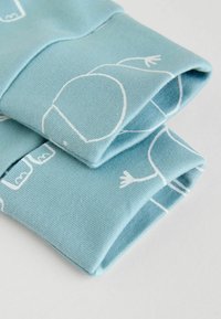 Light blue fabric with a textured weave, featuring white line drawings of figures. The edges are neatly folded, highlighting the design.