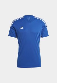 Maillot de sport bleu en tissu respirant. Présente des rayures blanches Adidas sur les épaules et un logo sur la poitrine. Design en V.