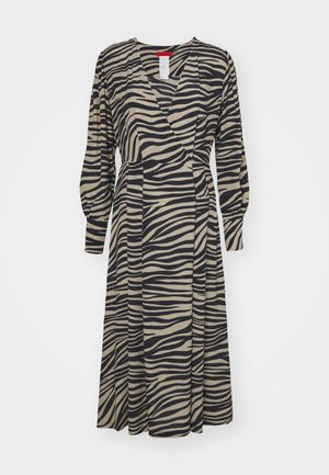Wickelkleid aus beigem Stoff mit schwarzen Zebra-Streifen, mit langen Puffärmeln und einem knielangen Rock.