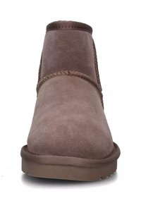 Stivaletto in suede marrone con punta rotonda, cuciture rinforzate e finitura liscia. Suola in gomma piatta per una buona aderenza.