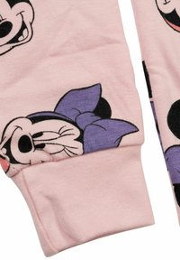 Tessuto rosa con stampe di personaggi dei cartoni animati, tra cui una Minnie Mouse in evidenza con un fiocco viola. Trama morbida, polsini a coste.