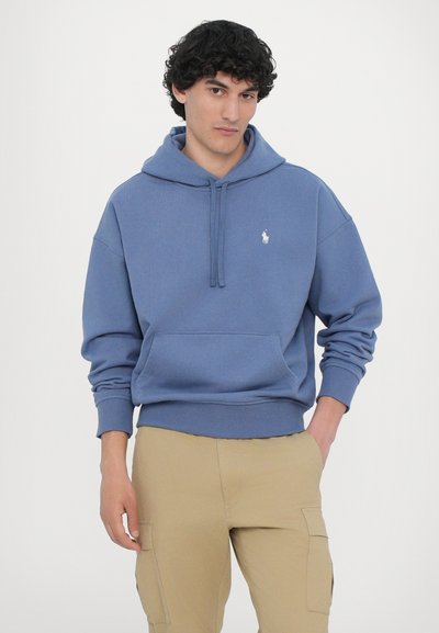 Blå bomulds hoodie med kængurulomme og snoretræk i hætten, med et lille hvidt logo på venstre bryst. Ribbet mansjetter og talje.
