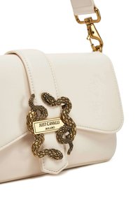 Borsa a tracolla in pelle color crema con design a pattina, caratterizzata da un motivo a serpente in metallo e una placca con logo dorato. Tracolla regolabile per maggiore versatilità.