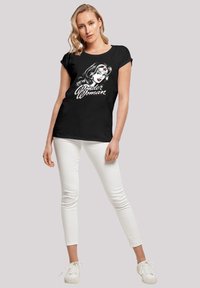 Black cotton t-shirt featuring a graphic of Wonder Woman's face and the text "Wonder Woman" in white, short sleeves, relaxed fit.