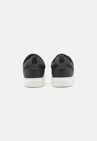 Black athletic shoes with a smooth textile upper, contrasting white rubber sole, and pull tabs at the heel for easy wear.