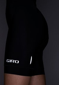 Sorte sykkelshorts laget av elastisk stoff, med en hvit logo "GIRO" og subtile designlinjer. Sletten tekstur med en tettsittende passform.