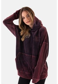 Oversized bordowy hoodie o miękkiej teksturze, z przednią kieszenią i haftowanym logo. Posiada przestronną kaptur i luźne rękawy.