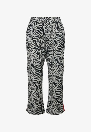 Pantalons à imprimé zèbre noir et blanc avec une coupe décontractée, taille élastique et fentes latérales révélant des accents rouges aux ourlets.