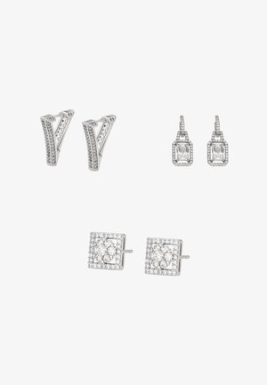 Trzy pary srebrnych kolczyków z diamentami: zakrzywione koła, prostokątne kolczyki wiszące oraz kwadratowe kolczyki na sztyft z grupą diamentów.