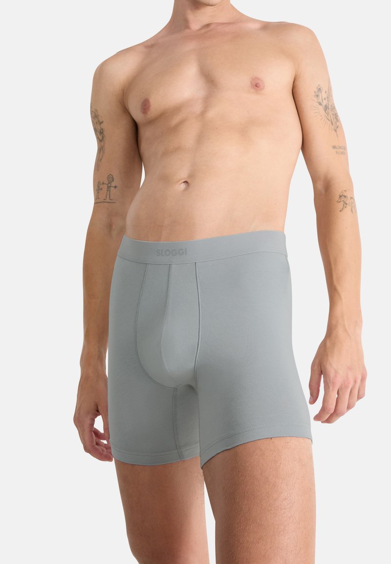 Světle šedé boxerkové trenýrky vyrobené z jemného, elastického materiálu s širokým pasem. Mají přední kapsu a bezšvové otvory pro nohy pro maximální pohodlí.