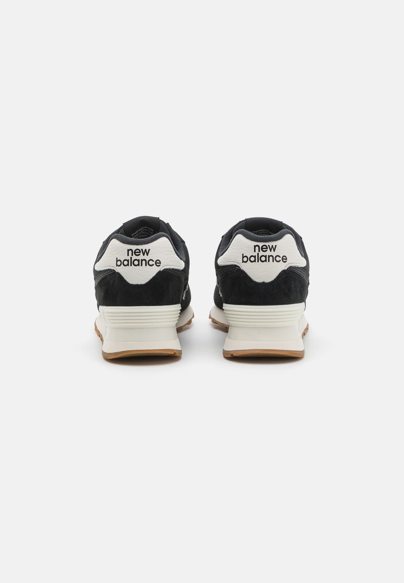 Schwarze Wildleder- und Mesh-Sportschuhe mit weißen Akzenten und "New Balance"-Logo an der Ferse, ausgestattet mit einer leichten Gummisohle mit strukturiertem Finish.