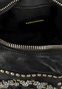 Zwarte leren handtas met zilveren en gouden versieringen, voorzien van een ritssluiting en een gemergde binnenvoering.