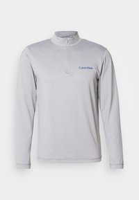 Μακρυμάνικο, ανοιχτό γκρι φούτερ με φερμουάρ και υφή υφάσματος. Διαθέτει το μπλε λογότυπο της Calvin Klein στο στήθος. Απλός, αθλητικός σχεδιασμός.